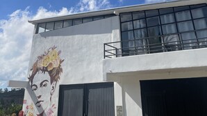 A modern building with a large window and a mural of a woman's face on the side. - Wine country In Valle de Guadalupe (Valle de Guadalupe)