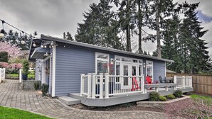 En lille, etplans bygning med en veranda, et overdækket udeområde og et træhegn.