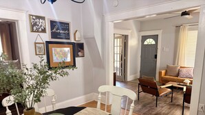 Una habitación con una mesa de comedor, sillas, un jarrón y un mapa en la pared.