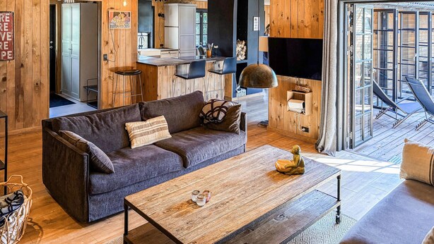 A cozy living room with a sofa, coffee table, and a TV. - 5 bedroom nice home in Nexø (Nexø)