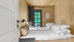 A wooden room with two beds, a door, and a window. - 5 bedroom nice home in Nexø (Nexø)