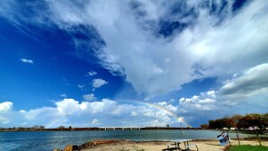 A bridge over water with a rainbow, picnic tables, and an American flag. - Buckeye Bungalow charming and cozy cottage, close to everything  (Port Clinton)