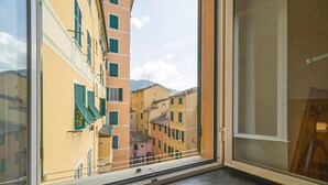 A window view of a narrow street with buildings, a clear sky, and a mountain in the background. - 2 bedroom gorgeous apartment in Camogli (Camogli)