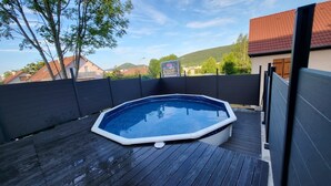 A rectangular hot tub on a wooden deck with a dark fence surrounding it. - Pro home (Besançon)