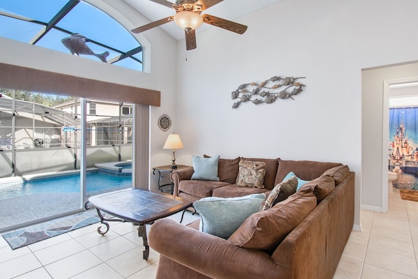Family room overlooking private pool, open to kitchen, perfect for relaxing.