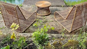Une jetée en bois s’étendant sur un lac paisible, entourée d’une végétation luxuriante.
