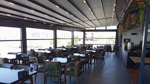 Un comedor interior espacioso con techos altos, ventanas amplias y diferentes opciones de asientos.