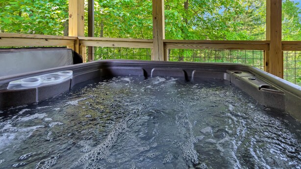 A hot tub with a wooden deck and a view of lush green trees. - Romantic Red River Gorge Cabin w/ Hot Tub, Pond Views & Dog Friendly (Frenchburg)