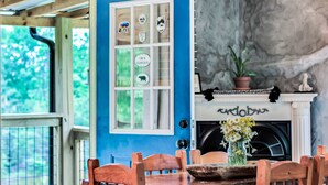 A room with a blue door, a fireplace, and a dining table with chairs. - Romantic Red River Gorge Cabin w/ Hot Tub, Pond Views & Dog Friendly (Frenchburg)