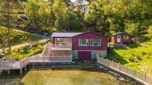 A two-story cabin with a deck and a small boat dock. - 3 bedroom awesome home in Sveio (Sveio)