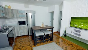 Una cocina moderna con comedor, televisor de pantalla plana y piso estampado.