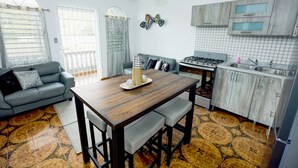 Una cocina moderna con una mesa de comedor, un sofá gris y una isla de cocina.