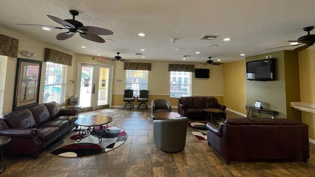A spacious lobby with leather sofas, a coffee table, and ceiling fans. - 5 minues to the theme park. Family sized communy pool (Kissimmee)