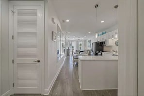 A modern kitchen with white cabinetry, a central island, and pendant lighting.