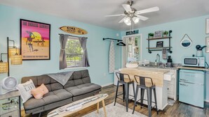 A compact living space with a kitchenette, a sofa, a dining area, and a ceiling fan. - Tiny Home Near the Bay by Beach's, Pensacola, Foley, Gulf Shores, Orange Beach
 (Elberta)