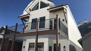 A two-story building with a balcony and a view of a snowy mountain. - Two apartments in one house (Silverton)