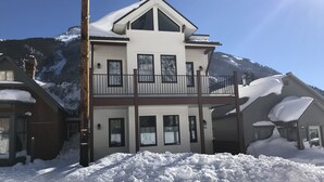 A two-story chalet with a balcony, surrounded by snow-covered mountains. - Two apartments in one house (Silverton)