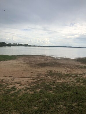 Une plage avec un rivage sablonneux et une étendue d’eau calme.