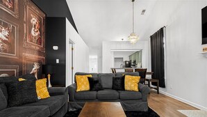 A modern living room with a dark grey sofa, wooden coffee table, and a black rug. - Midnight Lexington Newly Remodeled Designer Stay (Lexington)