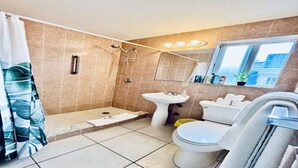 A bathroom with a shower, sink, toilet, and a window. - Beach Tide Motel - #5 Studio 1 King bed (Hollywood)