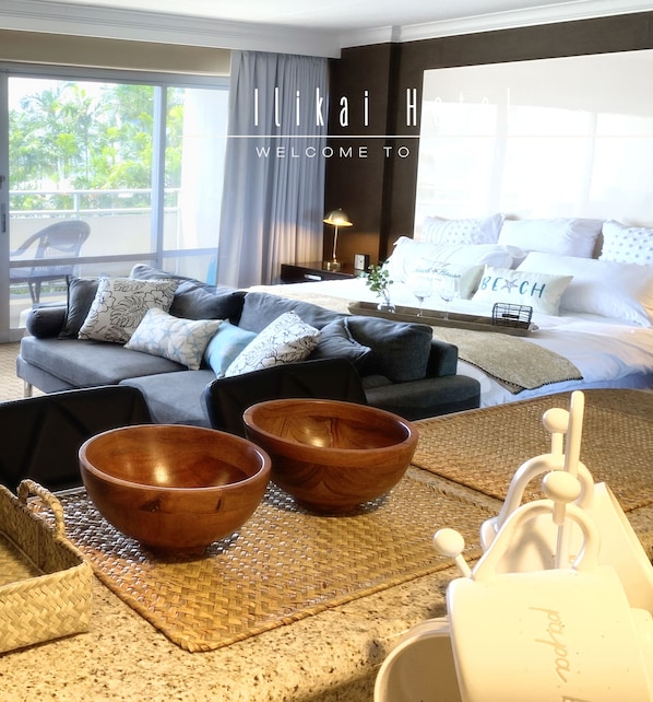 A modern hotel room with a large window, a sofa, a coffee table, and a tray with bowls and a vase. - Ocean View Waikiki Luxury Ilikai Hotel~ (Honolulu)