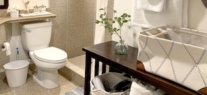 A modern bathroom with a toilet, bidet, and shower. There is a sink with a mirror, a small table with a vase, and a towel rack with towels. - Ocean View Waikiki Luxury Ilikai Hotel~ (Honolulu)