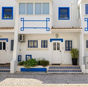 A white building with blue trim and patterned windows.