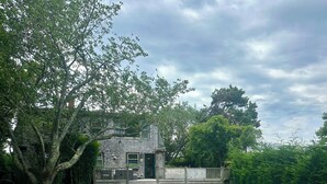 A rectangular swimming pool with a stone deck, surrounded by a grassy lawn and a wooden fence. - New Pool Lovely Home Mins away from Town & Beach (Nantucket)