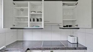 Eine Küche mit weißen Schränken, einer Granitarbeitsplatte, einem Toaster und einem Herd.