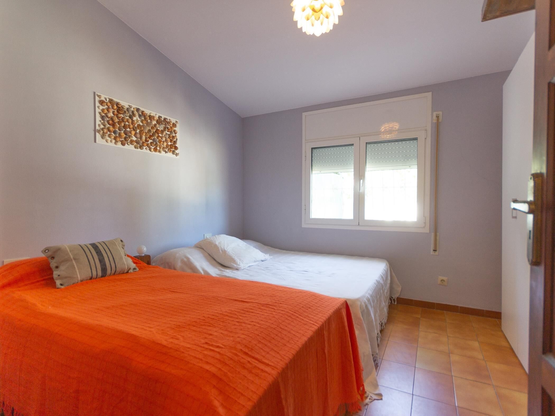 Een slaapkamer met een bed, een raam en een decoratie aan de muur.