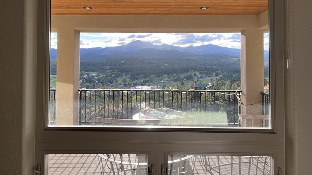 Ein Balkon mit Blick auf eine gebirgige Landschaft.