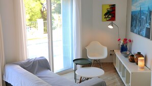 Ein Zimmer mit einem Bett, einem kleinen Tisch, einem Stuhl, einem Schreibtisch mit Dekoration und einem Bild an der Wand.