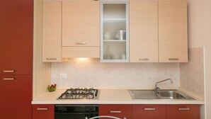 Una cocina con estufa a gas, pileta y alacenas.