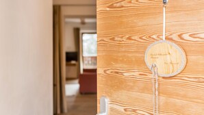 Une porte en bois ornée d’une plaque ronde et d’un porte-clés suspendu.