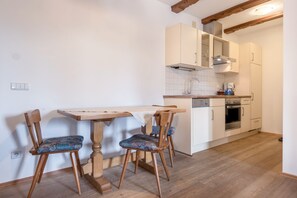 A kitchen with wooden cabinets, a countertop, a sink, and a stove.