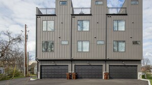 Un immeuble moderne à plusieurs étages, doté d’un toit plat, de grandes fenêtres et d’un garage.