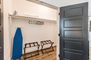 A hallway with a white wall, a blue surfboard, and two wooden benches. - Modern & Stylish Townhome with Cozy Rooftop (Nashville)