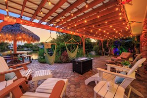 The back patio is perfect for bird-watching, with seating for 9 under the shaded pergola and 6 under the tiki hut. Enjoy the serene atmosphere as birds flit about. - Magical Manatee Waterfront Cove | Near IRB (Largo)