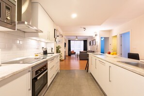 A modern kitchen with white cabinets, stainless steel appliances, and a central island. - Apartment 'Casa Malaga' with Terrace, A/C & Wi-Fi (Málaga)