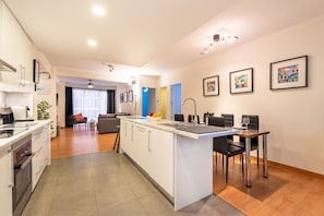A modern kitchen with a central island, a dining area with a table and chairs, and a living room with a sofa and a coffee table. - Apartment 'Casa Malaga' with Terrace, A/C & Wi-Fi (Málaga)
