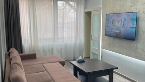 A modern living room with a brown sofa, a small table, and a TV mounted on the wall. - Luxury2BED1Bath/central Yerevan Wi-Fi/2nd Floor/Demrtchyan40./ARMTRAVElTURE.com (YEREVAN)