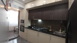 A modern kitchen with dark wooden cabinets, a black countertop, and built-in appliances. - Luxury2BED1Bath/central Yerevan Wi-Fi/2nd Floor/Demrtchyan40./ARMTRAVElTURE.com (YEREVAN)