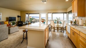Una cocina moderna con una isla grande, armarios de madera y vistas al exterior.