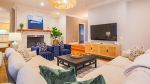Ein Wohnzimmer mit Kamin, Sofas, Couchtisch und Fernseher.