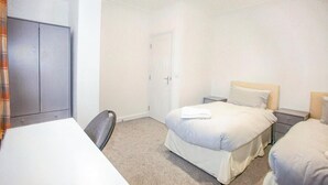 A hotel room with a bed, bedside tables, a desk, and a wardrobe. - Watford WD18 - Homely 2Bedroom/1Bathroom Flat w/ FREE WIFI & FREE PARKING (Watford)