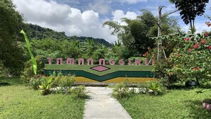 A sign with the text "TOMANACCI" surrounded by greenery and a pathway. - Camping Ground Taman Nggirli (Srimulyo)