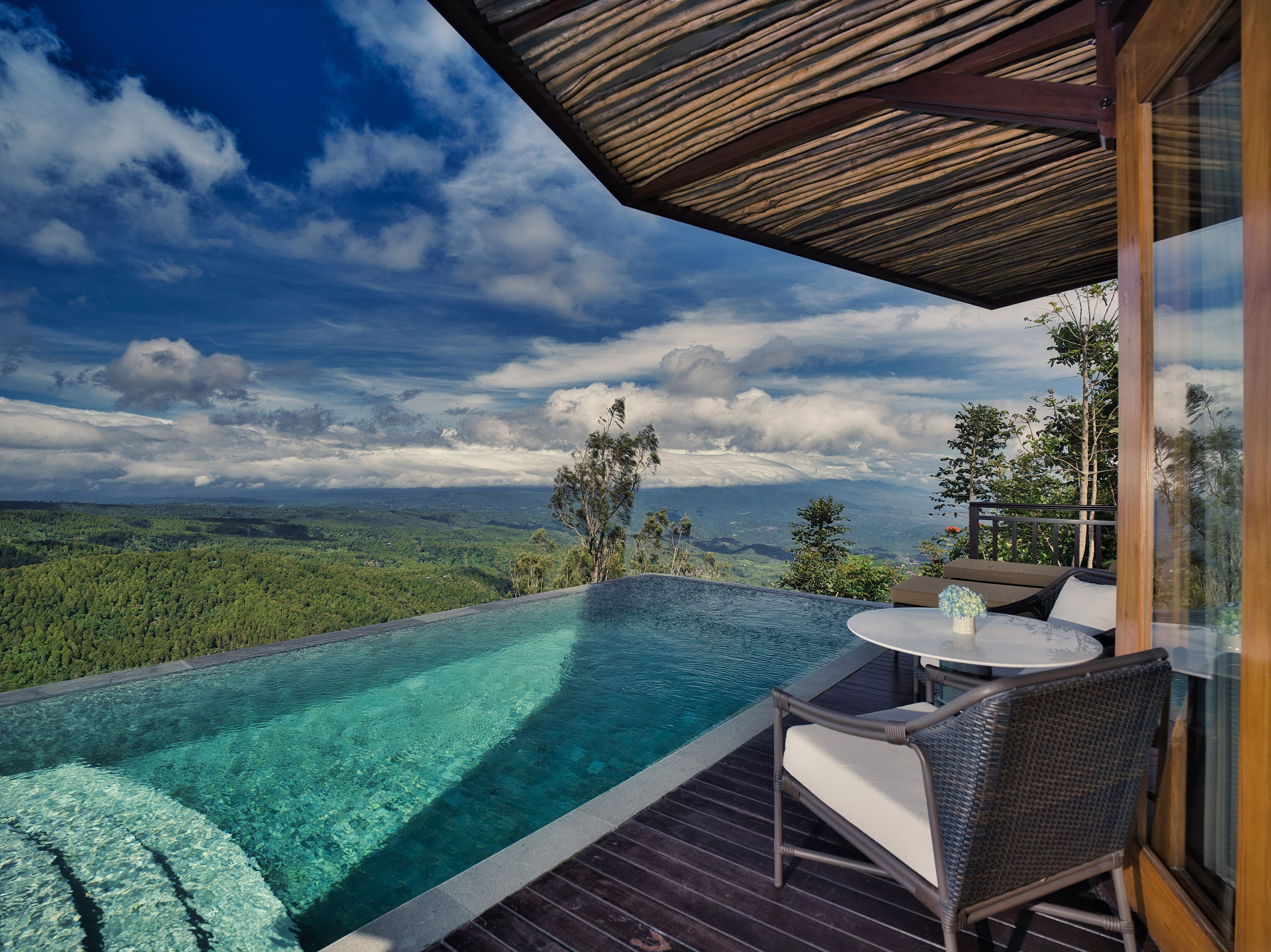 Una piscina infinita con vistas despejadas a un paisaje montañoso.