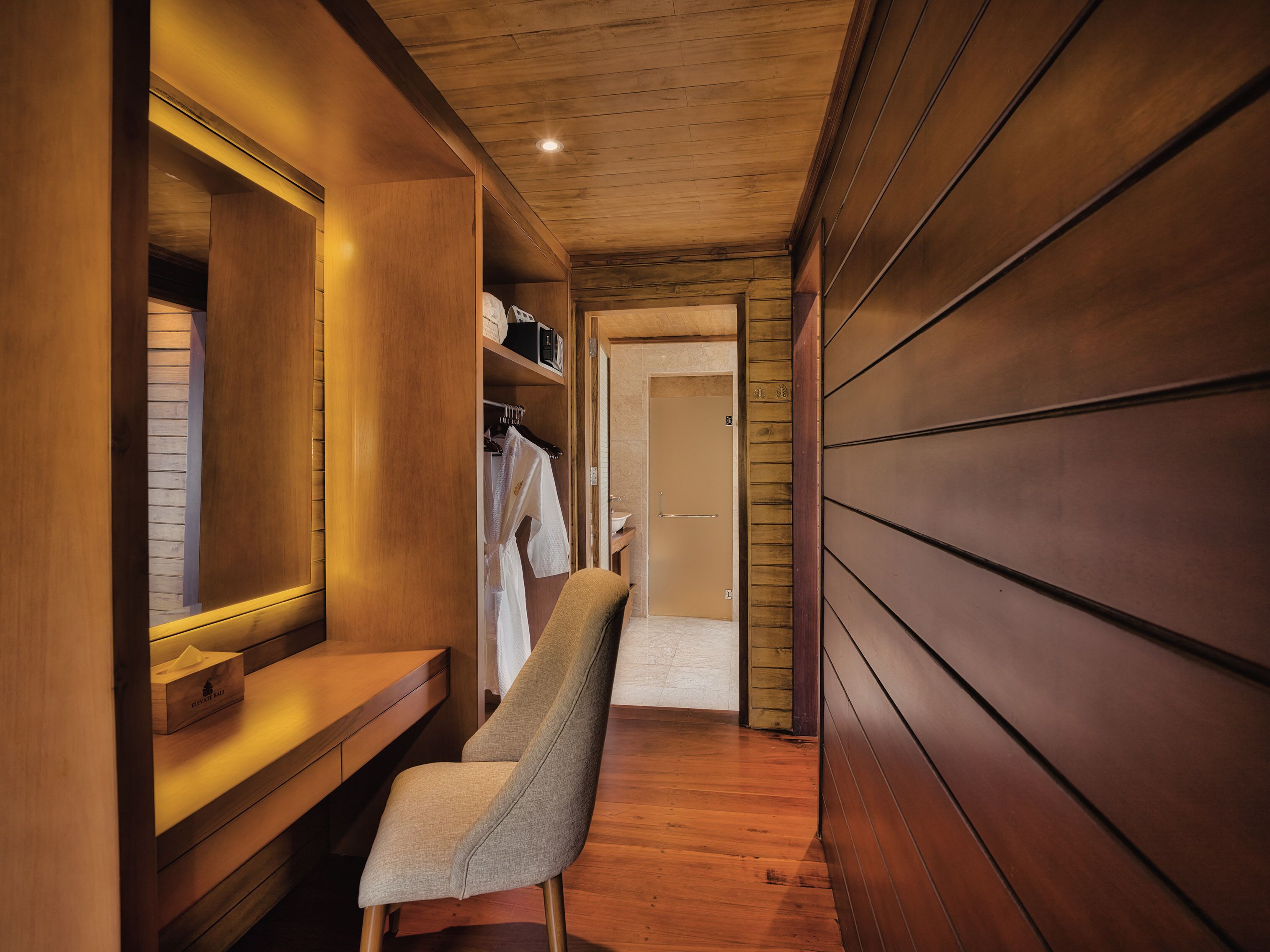 Un intérieur en bois avec un banc, un miroir et une porte donnant sur une autre pièce.