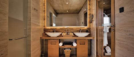 Une salle de bain moderne avec des éléments en bois, un grand miroir et deux lavabos.