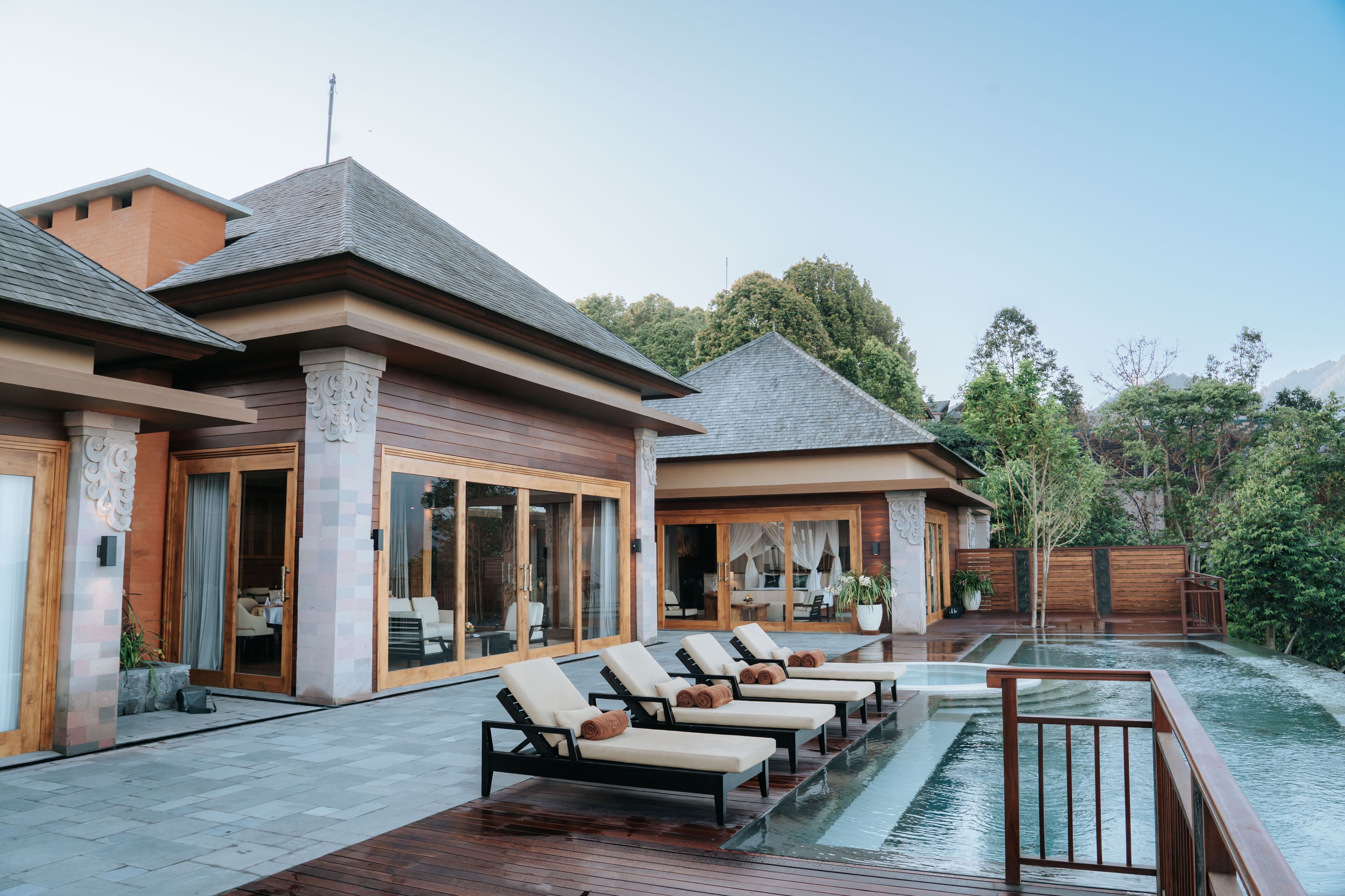 A resort with a pool area, lounge chairs, and a wooden deck.